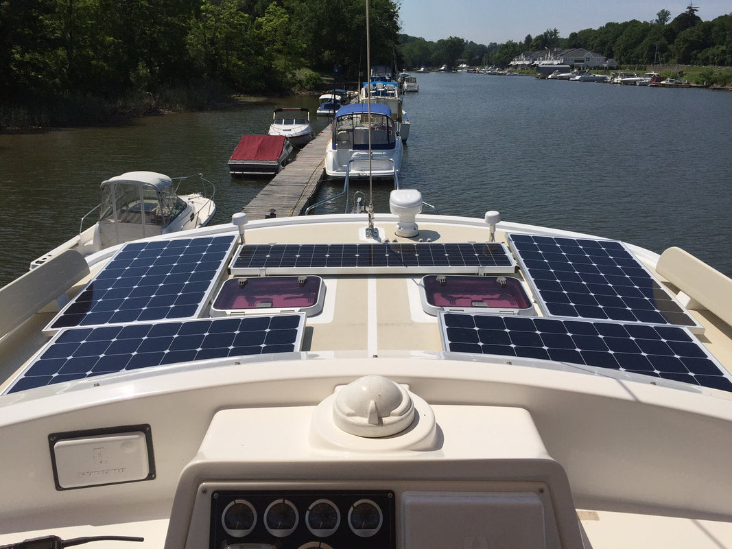 2 100 Watt, 2 120 Watt SunPower Cell marine solar panels and a narrow Fifth Panel on a Kayde-Krogen